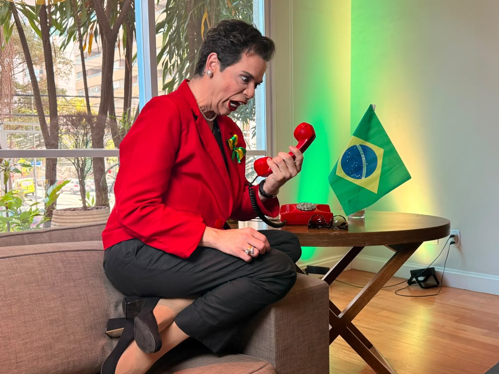 Gustavo Mendes em personagem satírica com telefone vermelho